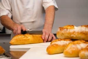 Image of Baker Cutting Bread for Learn Q Understanding Food Safety in the Manufacturing Industry blog