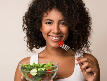 Image of woman eating salad for Learn Q The Most Popular Vegetables Consumed in The UK blog