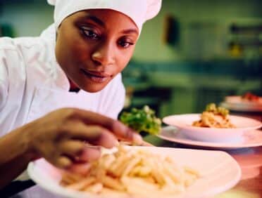 Image of Female Chef Plating up Dishes for Learn Q The Key Components of Level 2 Food Training Course blog