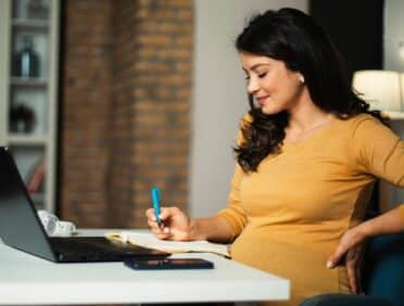 Image of Pregnant Worker at Her Desk for Learn Q Health and Safety Pregnant Workers and New Mothers blog